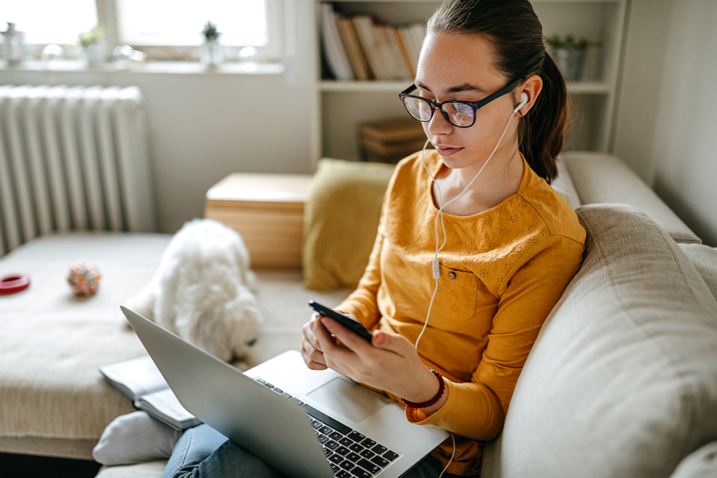 Teen using phone and laptop